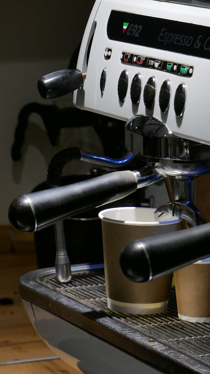 about-02 Close-up of a professional espresso machine brewing into cups in a café environment.